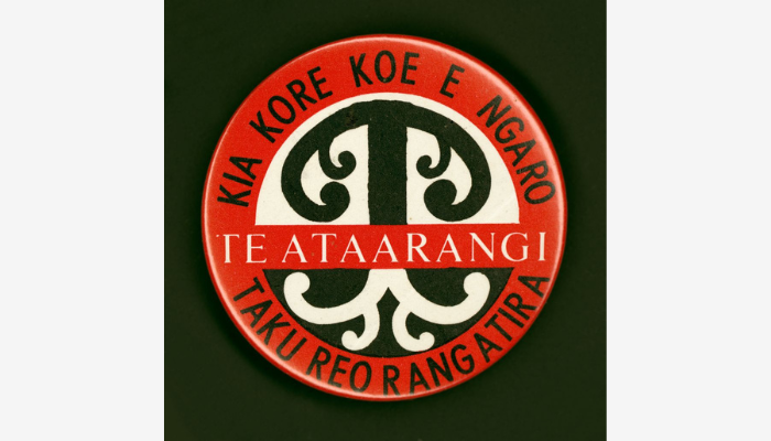 A badge with a tree and the words 'Te Ataarangi — Kia kore koe e ngaro taku reo rangatira'