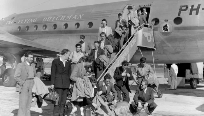 Black-and-white photo of passengers leaving the plane 'The Flying Dutchman' at Whenuapai airport.
