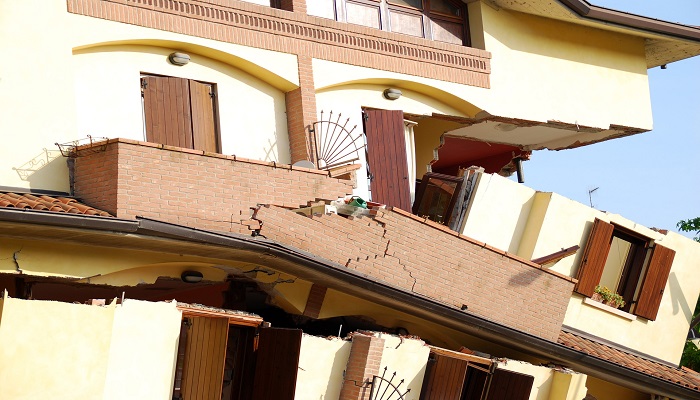 Colour photo of a building damaged by an earthquake. It shows floors that have fallen and detached from the building's structure.