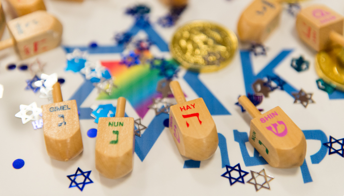 Colour photo of a Hanukkah game being played using wooden dreidels (four-sided tops) and coins.