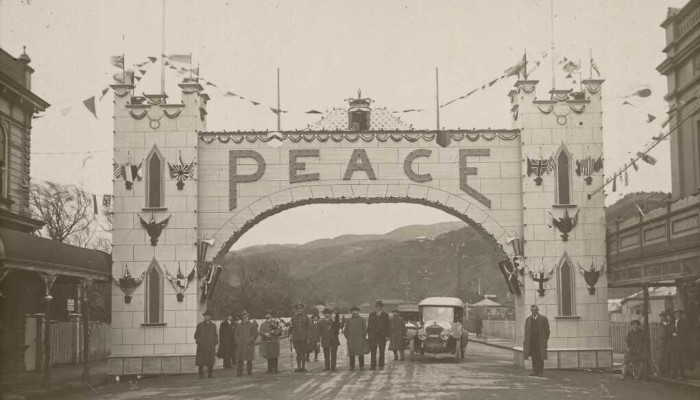 1919 photo showing a large arch across Jackson Street, Petone, displaying the word "Peace."
