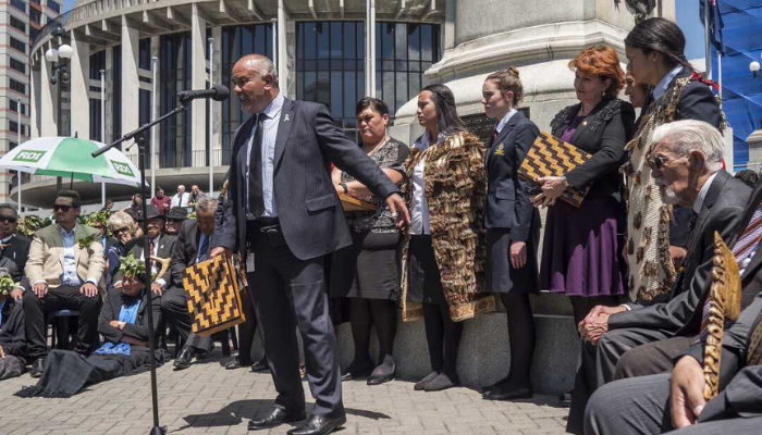 Te Ururoa Flavell speaking on Parliament grounds at the presentation of a petition organised by Ōtorohanga College students and supporters calling for a commemoration day for those killed in the New Zealand Wars.