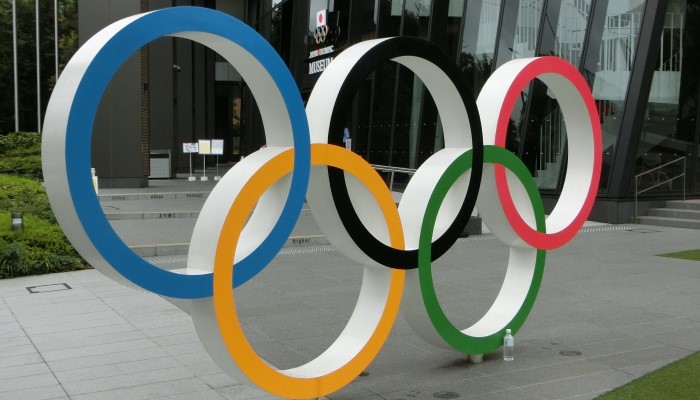 Colour photo of the 5 interlocked Olympic rings in front of the Japan Olympic Museum, Tokyo.