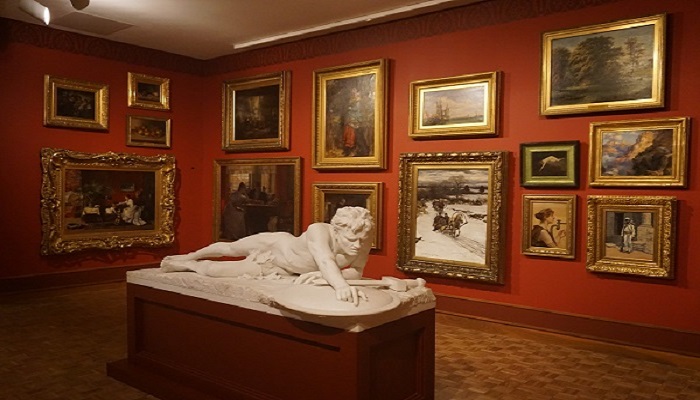 Colour photo of the Layton Art Gallery at the Milwaukee Art Museum. It shows a marble sculpture called 'The Last of the Spartans'. There are framed paintings on the walls.