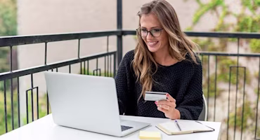 Woman on laptop with MoneySuperMarket logo displayed
