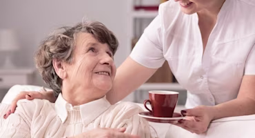 Woman being given a cup of tea