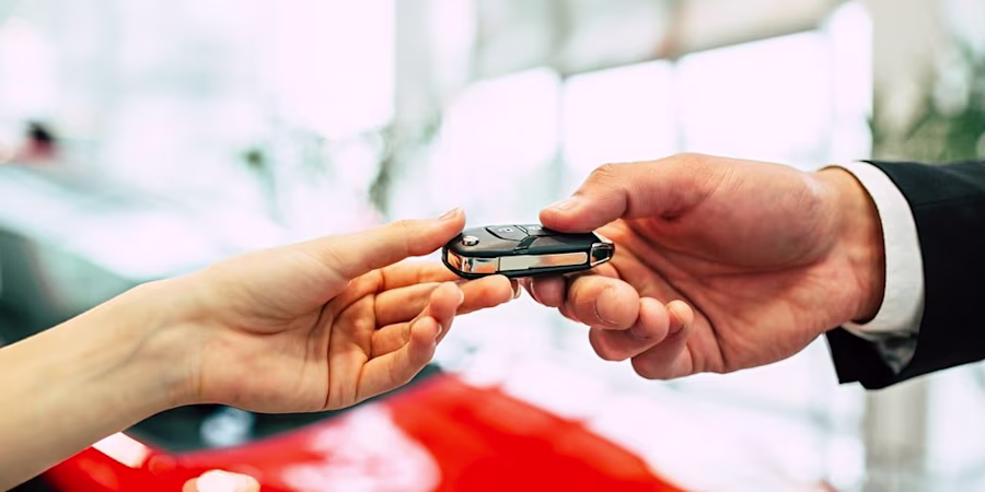 Hands passing car keys