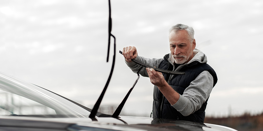man inspecting broken windscreen wiper