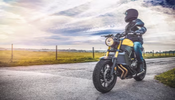 Photo of a person on a parked motorcycle looking at the view