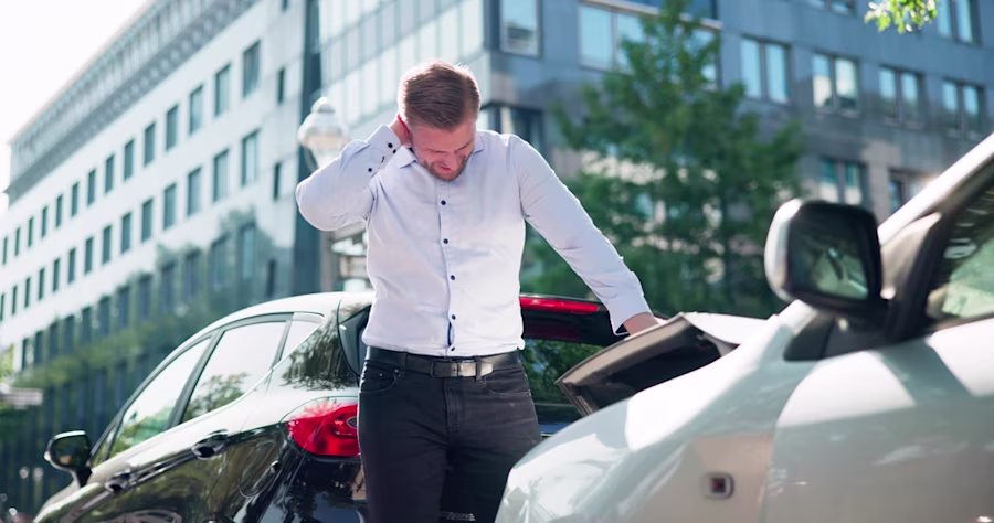 Man rubbing neck after car accident