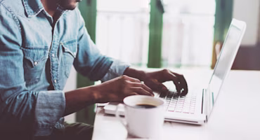Woman on laptop with MoneySuperMarket logo displayed