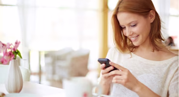 Woman on laptop with MoneySuperMarket logo displayed