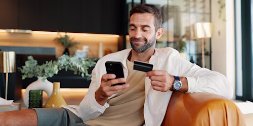 man using phone and credit card