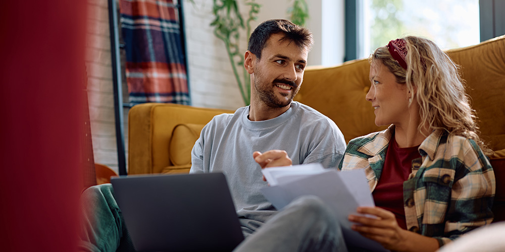 couple using laptop together and conversing