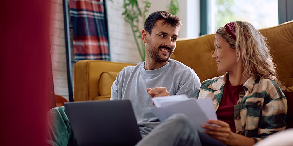 couple on laptop conversing with documents
