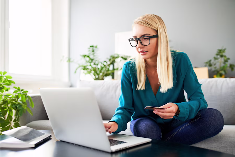 woman using laptop on sofa