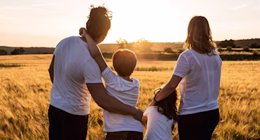 Family looking out at field during sunset