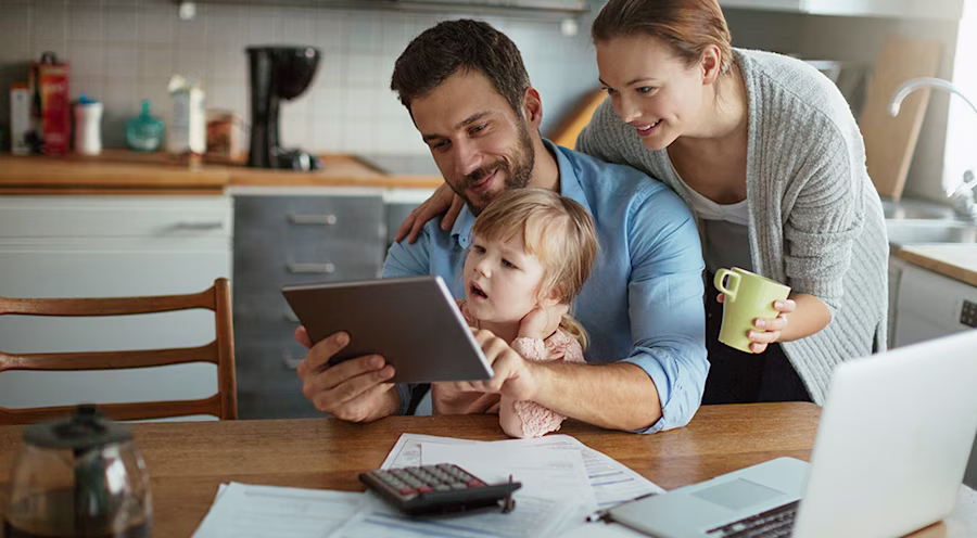 Parents and child using tablet and laptop