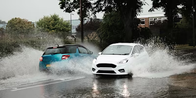 two cars driving through floodwater