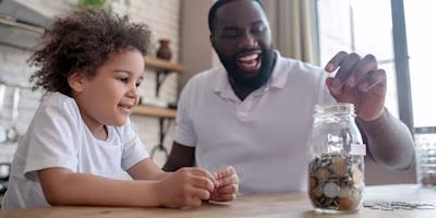 Father and son adding to a jar full of coins