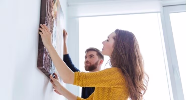 Couple hanging up artwork