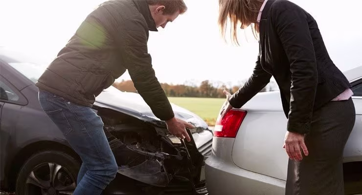 Two drivers pointing out damage after car collision