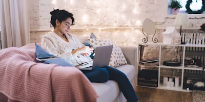 Woman on laptop with MoneySuperMarket logo displayed