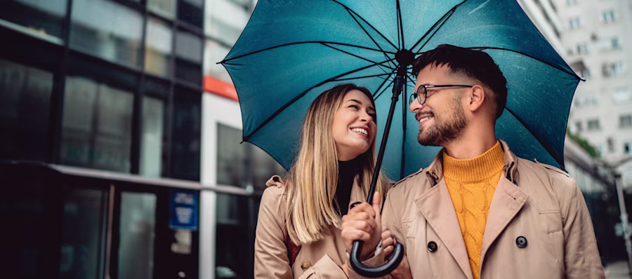 couple sharing umbrella smiling