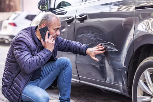 img-man-looking-at-damage-to-car