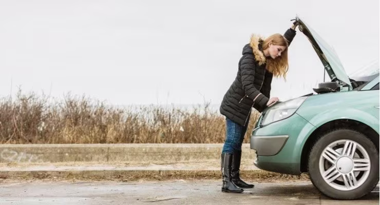 Lady looking into the engine compartment of a car