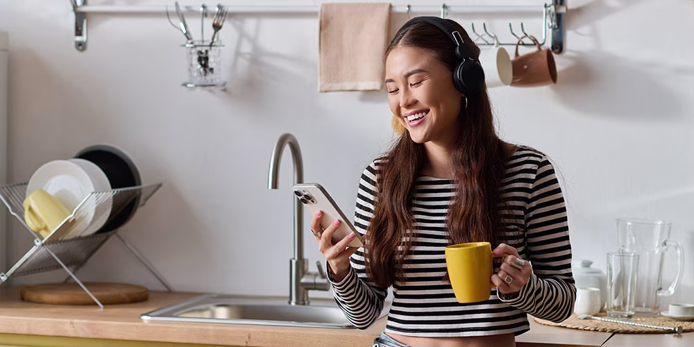 young woman with phone and tea