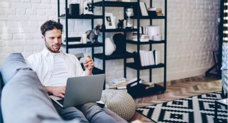 Man on laptop using card