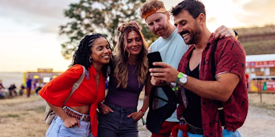 Group of friends at a festival looking at a phone