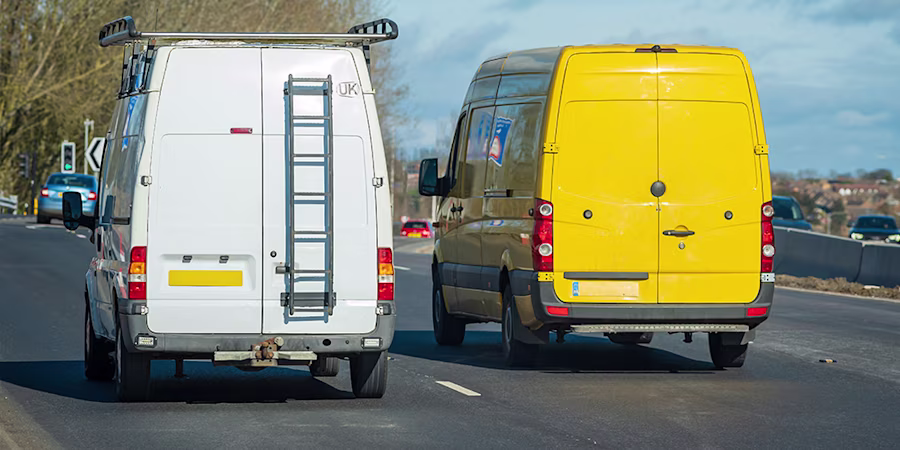 a yellow van and a white van driving next to each other