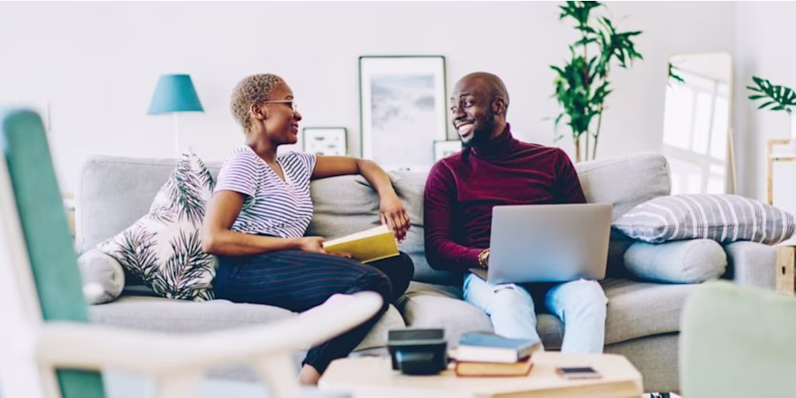 A man and woman on a sofa with a laptop