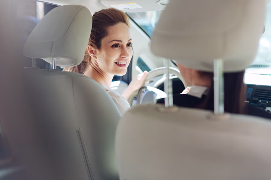 woman sat in car smiling
