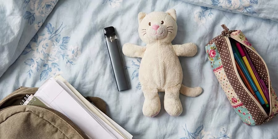 vape on teenager's bed among stuffed toy and school equipment