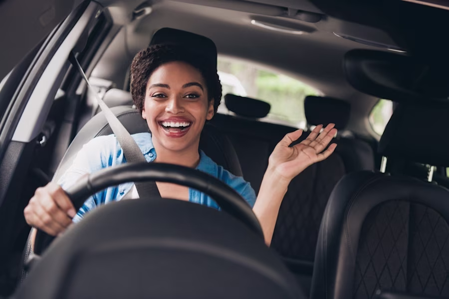 Woman driving car smiling