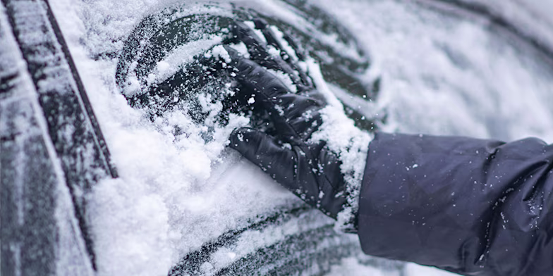 hand wiping frosty car window