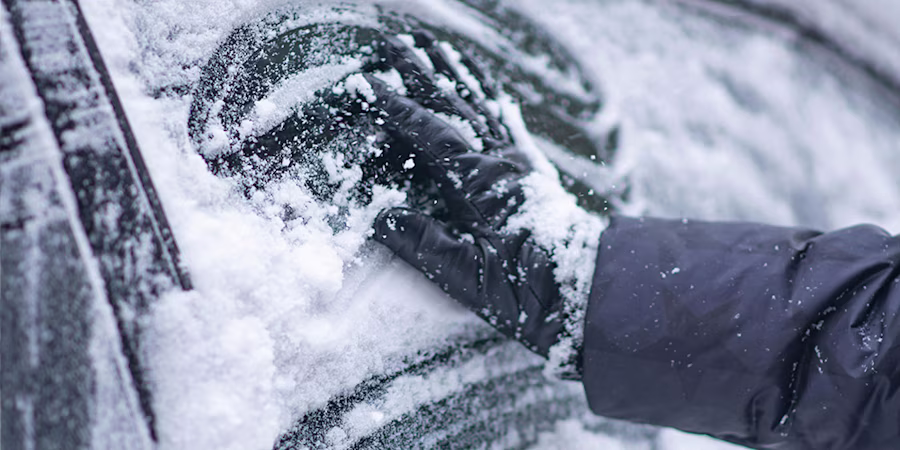 hand wiping frosty car window