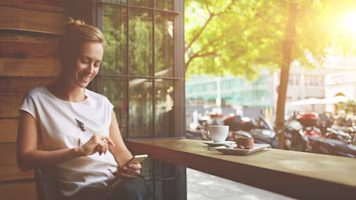 A lady in a cafe looking at a phone