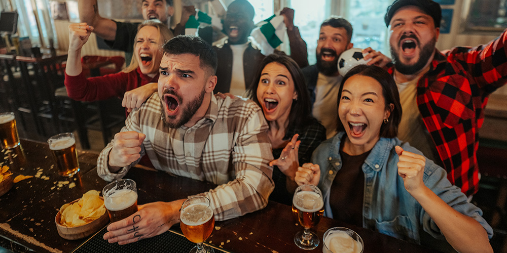 group of friends in a pub watching football