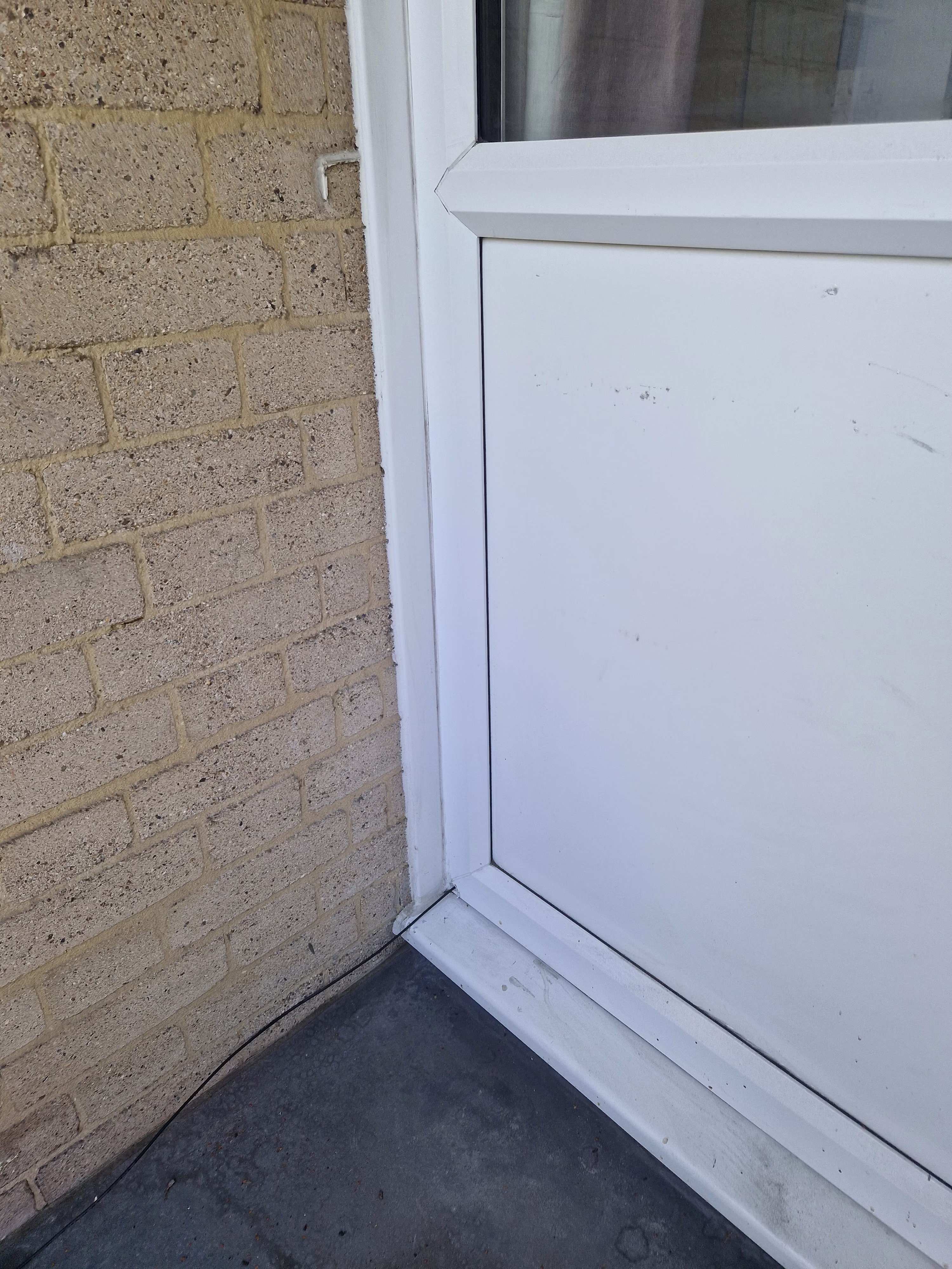 An FTTP cable running into a balcony door frame