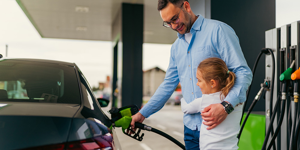 father and daughter refuelling car