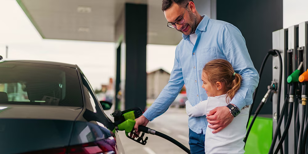 father and daughter refuelling car