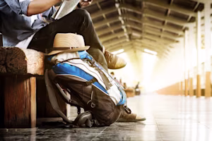 A backpack leans against a bench in a station