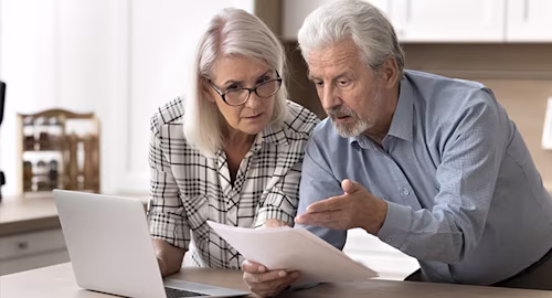 older couple using laptop confused