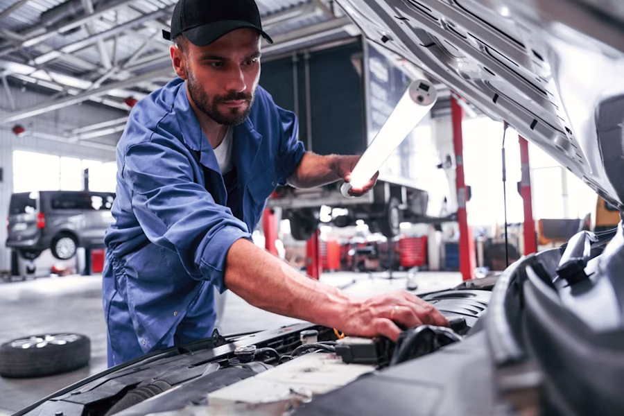 Mechanic servicing a black car