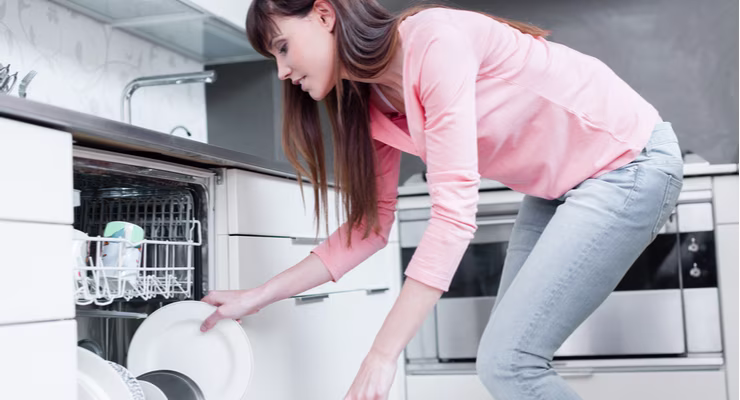 Woman using a dishwasher