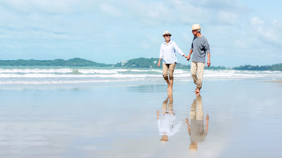 Older couple on beech holding hands